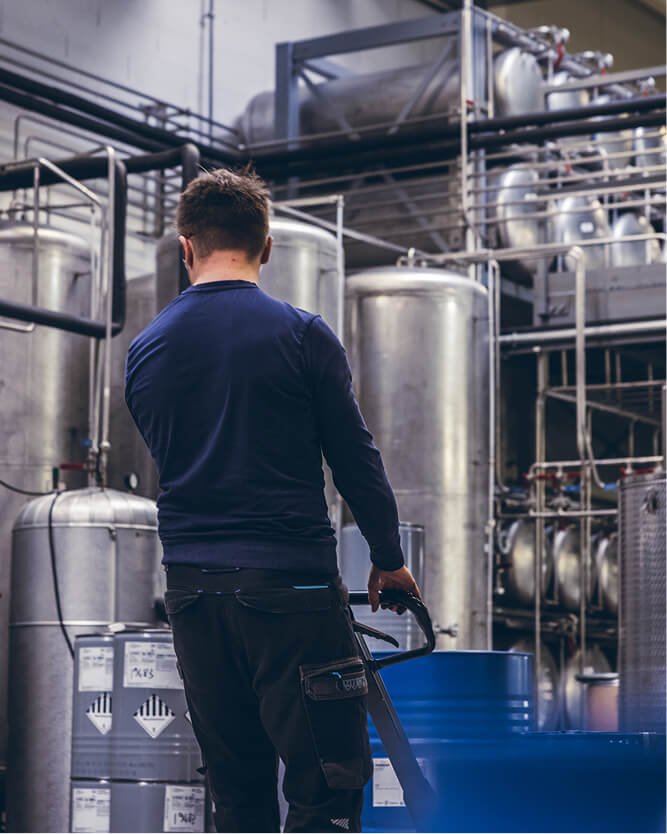 Une personne travaillant avec un transpalet dans un entrepot de stockage de produits chimiques